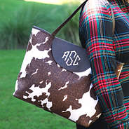 monogrammed cowhide tote bag on shoulder