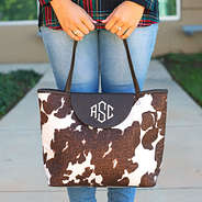 woman holding monogrammed cowhide tote in hands