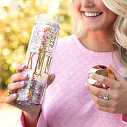woman taking a drink out of rose gold confetti water bottle