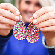 holding confetti leaf earrings