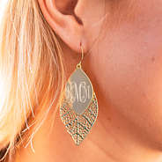 gold fall leaf earrings in ear