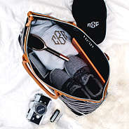 inside of monogrammed carry on bag with sneakers and hat