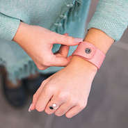 blush faux leather slap bracelet on wrist with mint cardigan