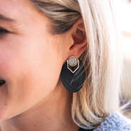 black and silver monogrammed leather earrings in ear