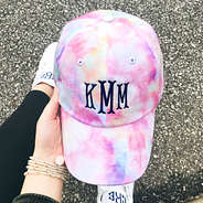 monogrammed tie dye hat in front of gravel