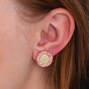 pink and gold monogrammed cluster studs in ear