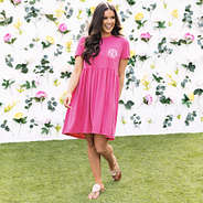 girl wearing monogrammed t shirt dress in hot pink with flower background