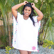 white monogrammed pom pom cover up in front of palms
