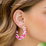 girl wearing pink and white flower resin hoop earrings