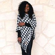 black buffalo plaid poncho by brick wall
