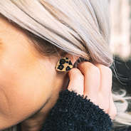 leopard print stud earrings in ears
