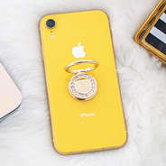 gold monogrammed rhinestone phone ring on yellow iphone