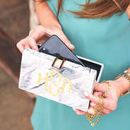 putting iphone into monogrammed box clutch