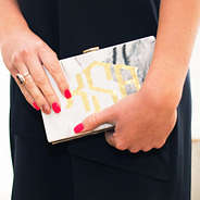 holding monogrammed box clutch