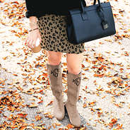 monogrammed riding boots with leopard skirt in fall leaves