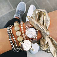 gold metallic scrunchie on wrist with watch and monogrammed bracelet