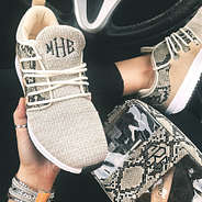 monogrammed snakeskin athletic sneakers in car with purse
