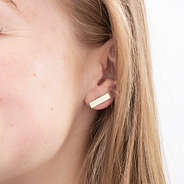 gold bar earrings in ear