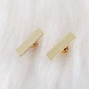 gold bar earrings on faux fur