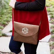 Brown Metallic Leopard monogrammed clutch wearing boots and sweater