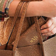girl putting metallic leopard monogrammed wallet in tote