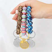 girl holding three new bracelet keychains