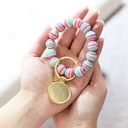 girl holding rainbow stripe key ring