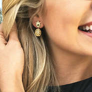 gold pineapple dangle earrings in ear