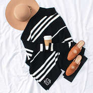 tan wide brim hat with black monogrammed sweater poncho