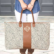 girl holding monogrammed spring leopard weekender in hands