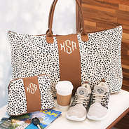 monogrammed spotted weekender and cosmetic bag on bench