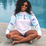 girl sitting by pool with living my best life t-shirt