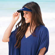 girl wearing sun visor and coverup at beach