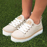 monogrammed platform sneakers from the side on turf grass
