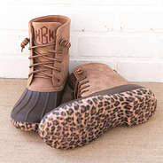 leopard bottom duck boots by white brick wall