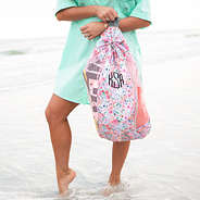 girl holding coral floral beach backpack