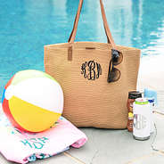 monogrammed straw tote bag sitting by the pool