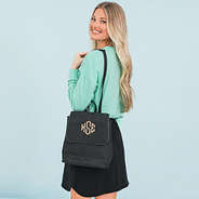girl with black monogrammed backpack purse over shoulder