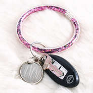 pink monogrammed confetti key ring on fuzzy rug