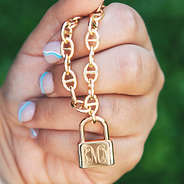 monogrammed lock chain necklace in hand