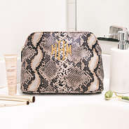 monogrammed snakeskin cosmetic case on bathroom counter