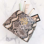 monogrammed snakeskin cosmetic case on marble