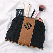 black and brown quilted travel makeup bag with cosmetics spilled out