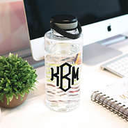 clear motivational water bottle with black monogram on desk