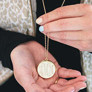 gold circular locket pendant in hand