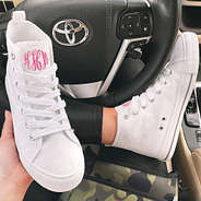 white monogrammed high top sneakers in car