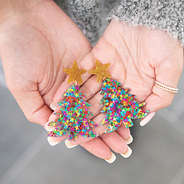 Holding Christmas Tree Earrings in Hands