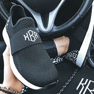 black and white monogrammed sneakers in car
