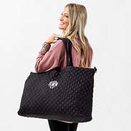 black diamond quilted weekender on shoulder
