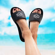 black monogrammed jelly slides with sky in the background